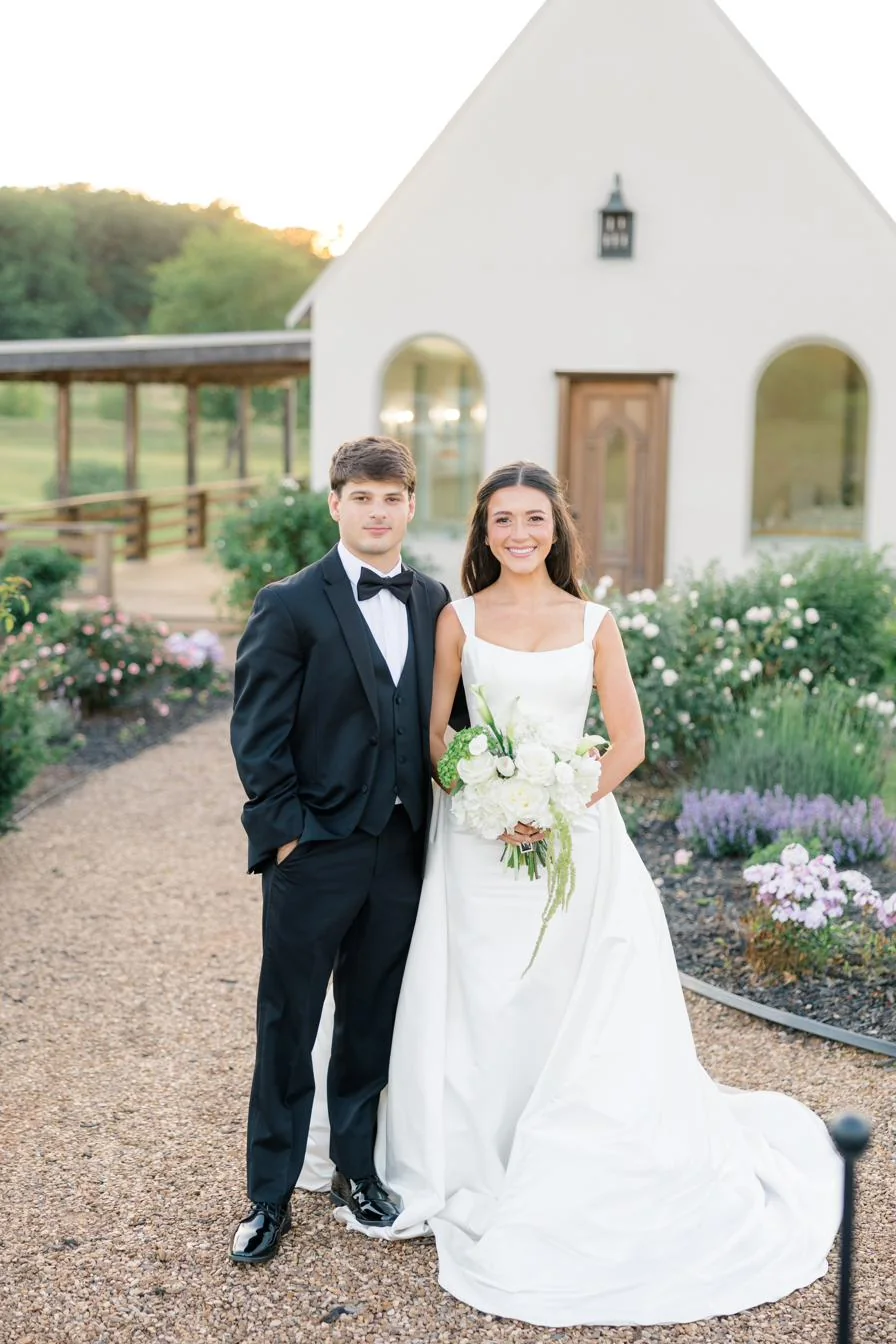 A couple in front of the chapel and rose gardens at Gateley Hill Gardens