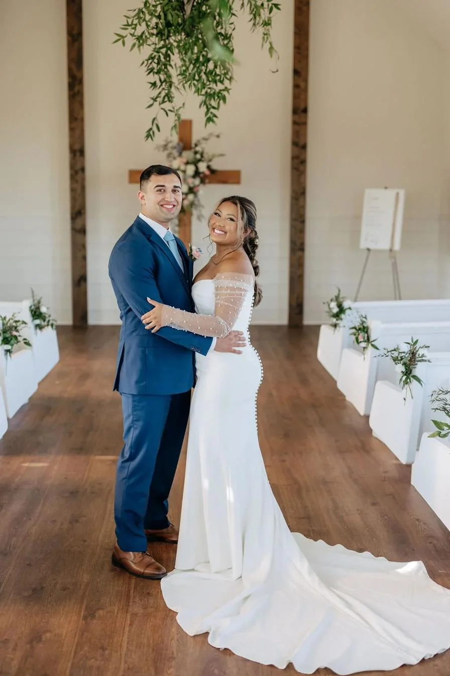 A couple at the chapel altar set with a wooden cross and greenery