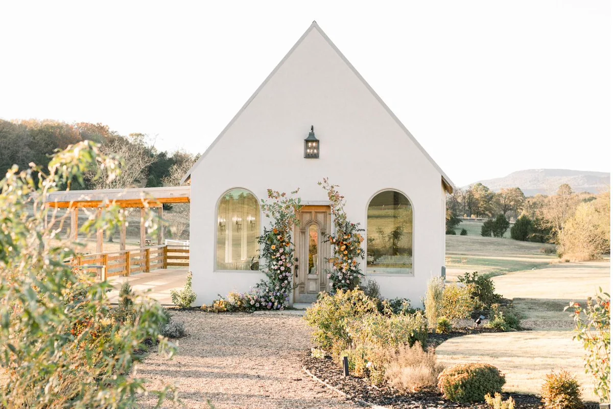 The white stucco chapel and gardens with Mt. Nebo behind at Gateley Hill Gardens